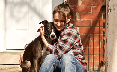 A young woman hugs her dog