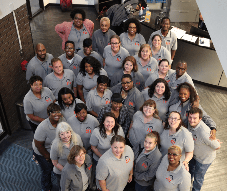 211 Staff smile up from the lobby