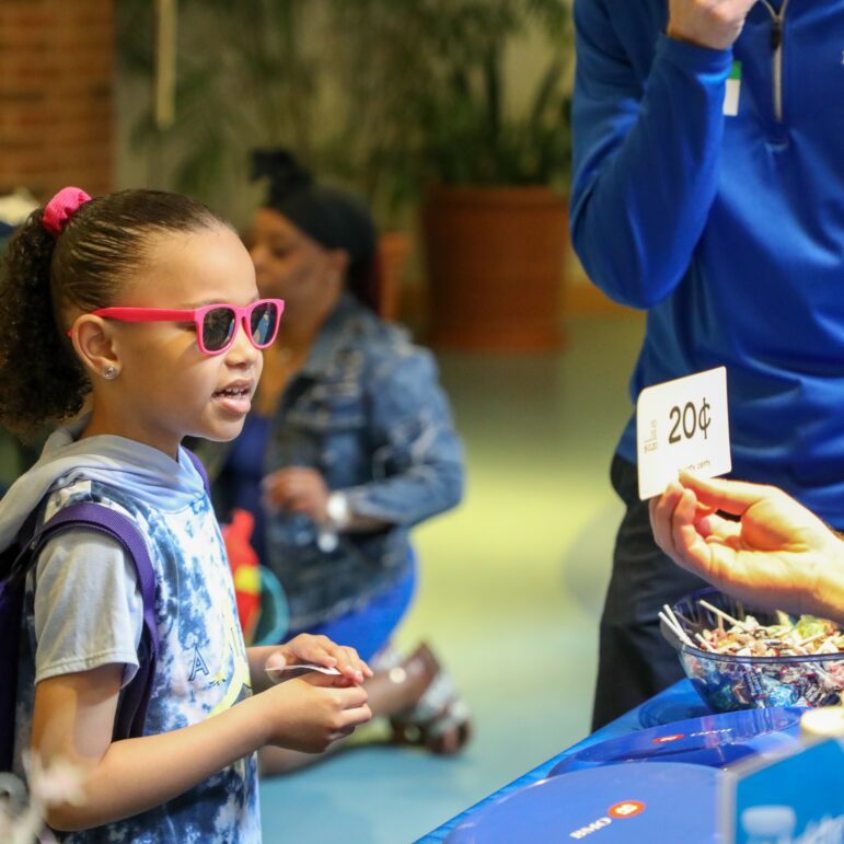 Child guesses how much an item costs at Money Smart Month's Zoo Safari.