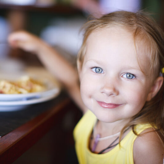 A young child eats at a table