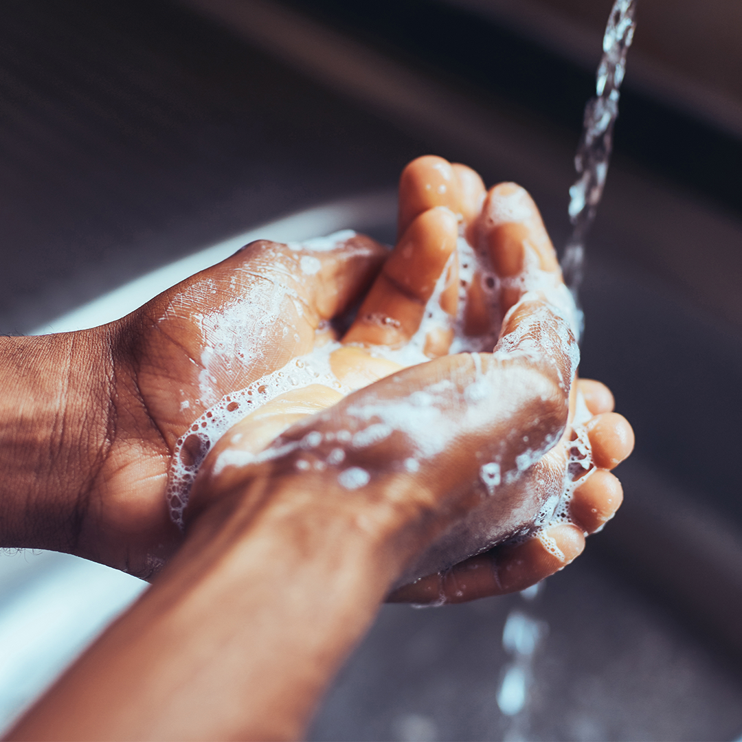 A person washes their hands with water and soap